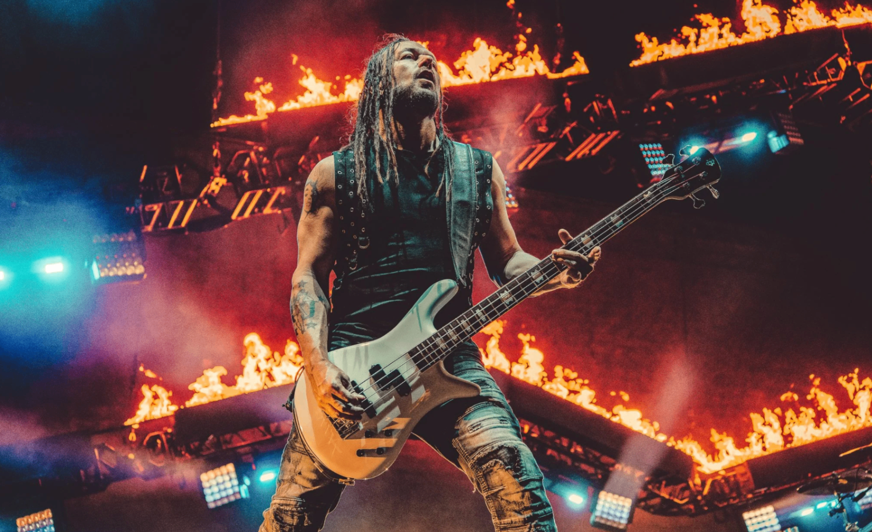 Bassist backlit by stage fire